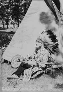 Chief Eagle Feathers in front of Tepee 'Lonliness'