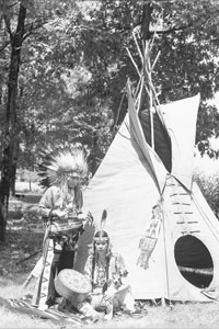 Chief standing Princess sitting in front of tepee