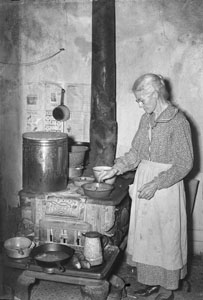 Grannie cooking at stove in old kitchen