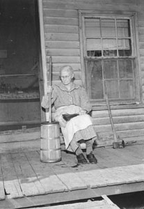 Grannie sitting on back porch churning