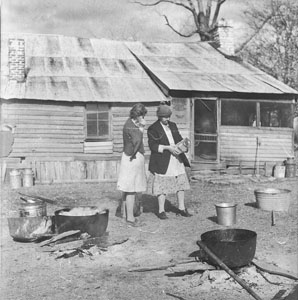 Aunt Minnie and Ruth looking at meat salt beside lard cooking kettle - Thanksgiving